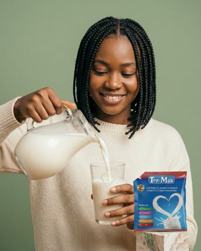 Hélène verse du lait dans un verre et présente un sachet de lait en poudre.